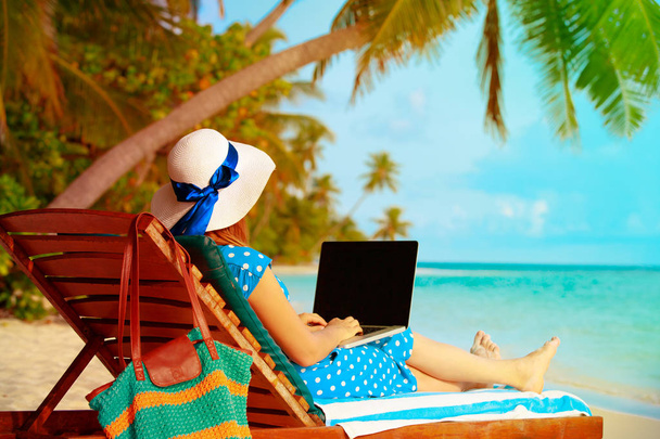 externe werk concept-jonge vrouw met laptop op strand - Foto, afbeelding