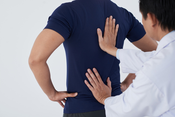 Trabalhador médico diagnosticando coluna vertebral de paciente desportivo
 - Foto, Imagem