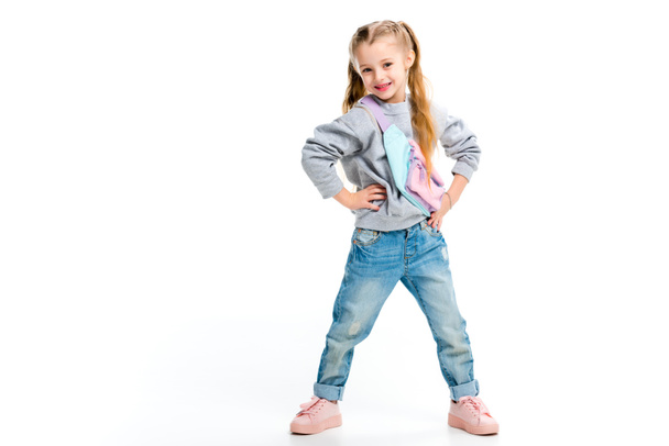 stylisches Kind, das mit Armen auf den Schenkeln steht, isoliert auf weiß - Foto, Bild