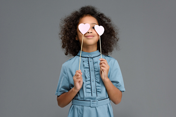 happy child covering eyes with hearts signs isolated on grey - Photo, Image