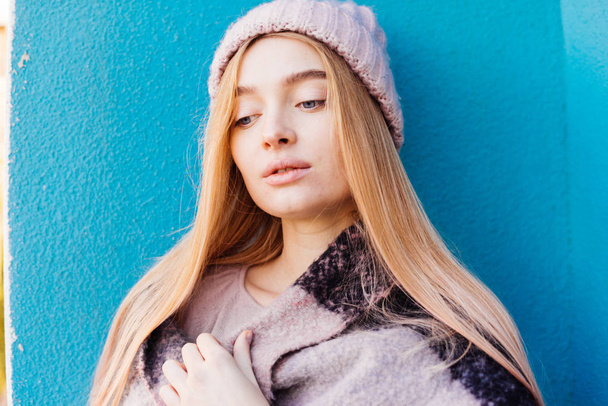 belle jeune fille blonde dans un chapeau rose chaud posant sur un fond de mur bleu
 - Photo, image