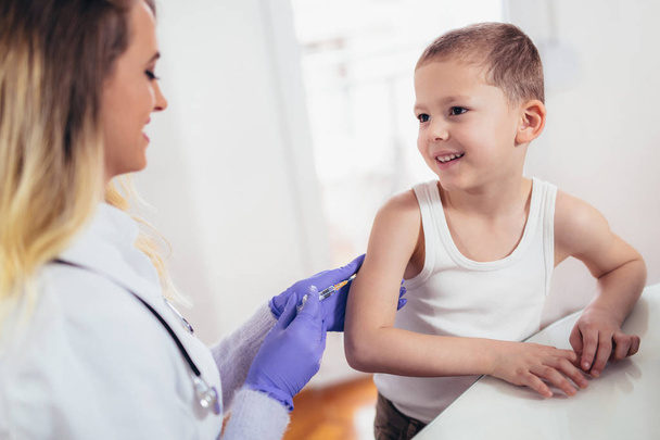 γιατρός που κάνει την ένεση εμβόλιο στο παιδί. - Φωτογραφία, εικόνα