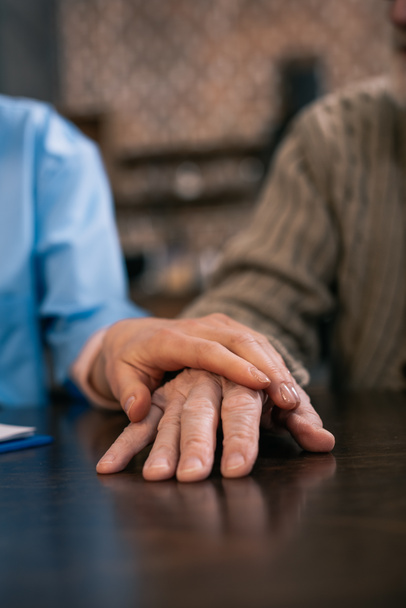 Caregiver supporting and holding hand of senior man  - Photo, Image