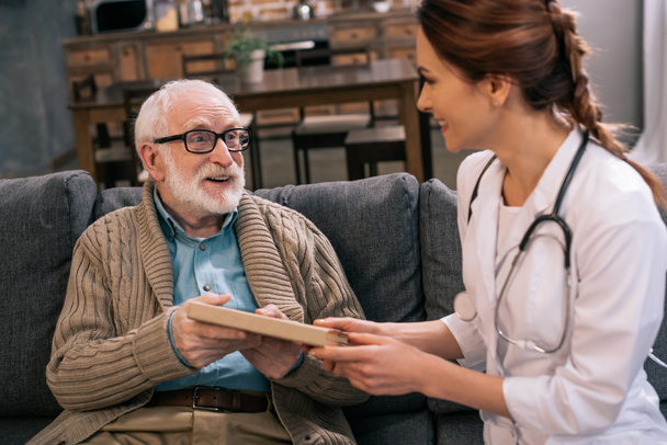 Docteur présentant le livre à un homme âgé
 - Photo, image