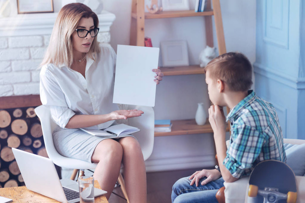 Female professional psychotherapist working with troublesome boy in office - Foto, Imagem
