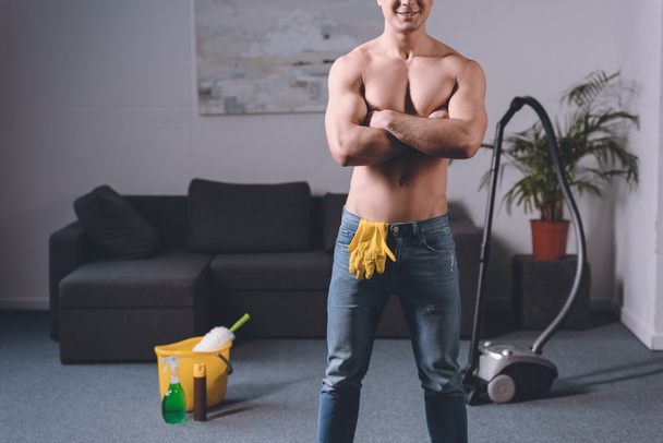 przycięte zdjęcie sexy shirtless człowiek stojący z skrzyżowanymi rękami, Rękawice gumowe w dżinsach - Zdjęcie, obraz