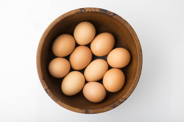 Jedzenie: Widok brązowy jaja w drewniana miska na białym tle z góry strzał studio tło  - Zdjęcie, obraz
