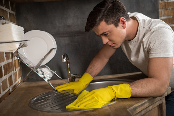 Μερική άποψη του όμορφος άνδρας καθαρισμού νεροχύτη στην κουζίνα - Φωτογραφία, εικόνα