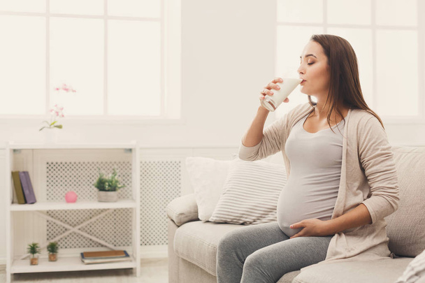 Raskaana oleva nainen juo lasi maitoa kopioi tilaa
 - Valokuva, kuva