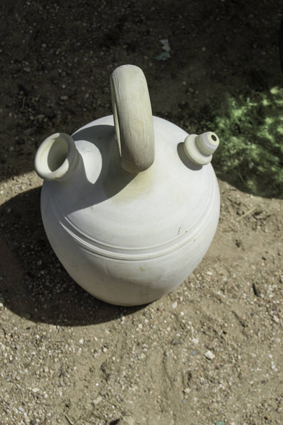 grande jarro de barro cerâmico espanhol / grande jarro de barro cerâmico espanhol descansando em um chão de sujeira e visto de cima
 - Foto, Imagem