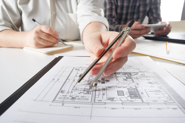 Architects working on blueprint, real estate project. Architect workplace - architectural project, blueprints, ruler, calculator, laptop and divider compass. Construction concept. Engineering tools. - Foto, afbeelding