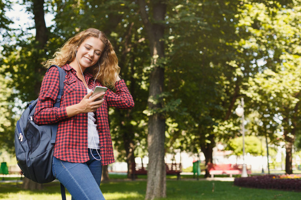 Όμορφη φοιτήτριας χρησιμοποιώντας κινητό smartphone σε εξωτερικούς χώρους - Φωτογραφία, εικόνα