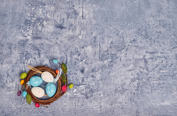 Easter background. Decorative Easter eggs in small nest. Holiday card with copy space, top view - Foto, imagen