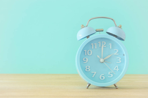 Image of spring Time Change. Summer back concept. Vintage alarm Clock over wooden table. - Foto, afbeelding