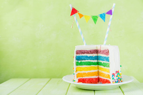 Birthday background - striped rainbow cake with white frosting - Fotó, kép