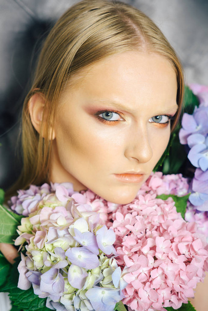 Young beauty woman face with blond hair and hydrangea - Foto, immagini