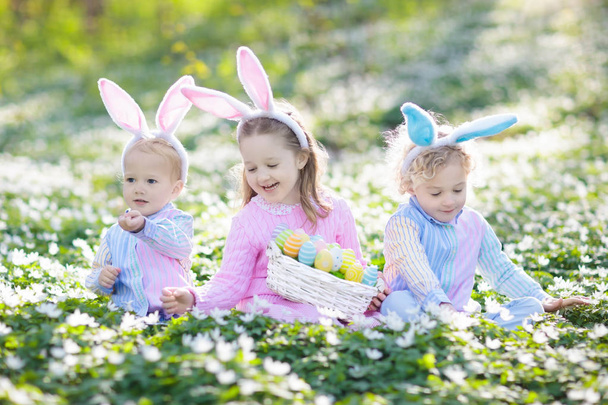 Τα παιδιά με αυτιών λαγουδάκι στο Πασχαλινό αυγό κυνήγι. - Φωτογραφία, εικόνα