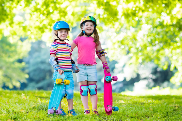 Niños montando monopatín en el parque de verano
 - Foto, Imagen
