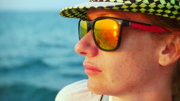 Νεαρή γυναίκα με καπέλο και γυαλιά ηλίου που ταξιδεύουν με σκάφος στο ηλιοβασίλεμα. 4k - Πλάνα, βίντεο