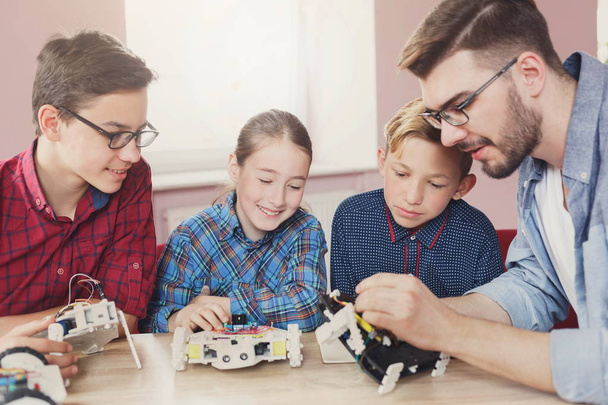 Stem education. Kids creating robots with teacher - Fotoğraf, Görsel