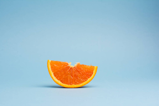 sliced orange fruit isolated on blue background - Foto, afbeelding