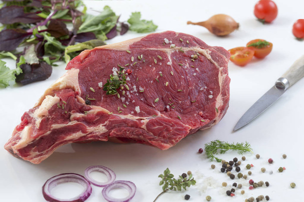 Raw T-bone Steak for grill or BBQ on cutting board with knife over on a white background, top view - Fotoğraf, Görsel