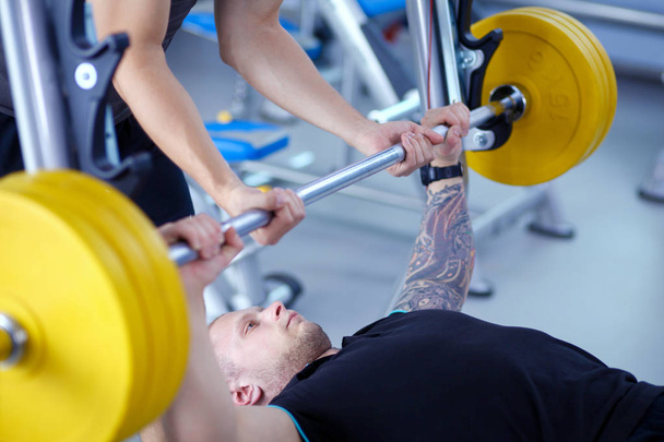 Bodybuilder with barbell in gym. Bodybuilder - Foto, afbeelding