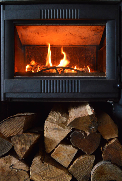 暖炉または木ストーブ暖房のためのアクションのリビング ルーム。薪で. - 写真・画像