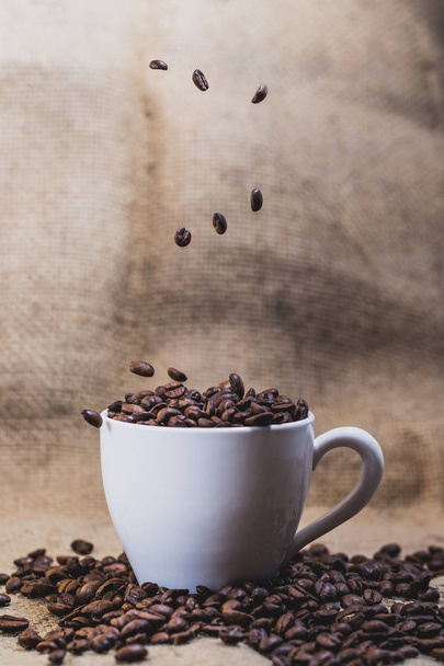 Кава в білій чашці з кавою на фоні
 - Фото, зображення