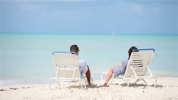 Щаслива пара відпочиває на тропічному пляжі на сонячному ліжку
 - Кадри, відео