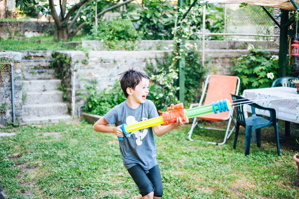 dzieci bawią się w ogrodzie z dział i karabinów wody na sunn - Zdjęcie, obraz