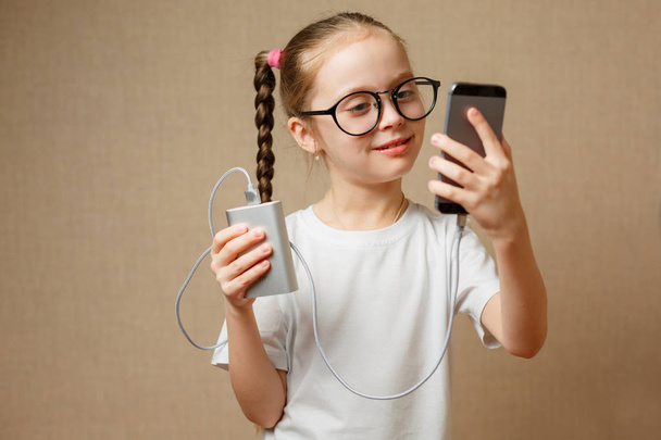 Linda niña usando un teléfono inteligente moderno
 - Foto, Imagen