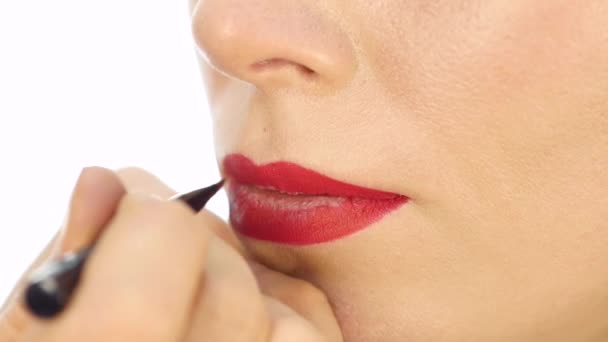 Professional makeup artist applying contour on lips of model. fashion industry cosmetics - Кадри, відео