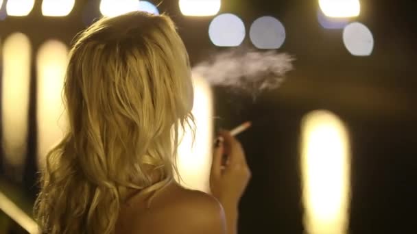 Girl smoking on riverbank - Video