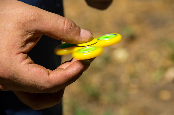 Mann spielt mit Fidget Spinner Stressabbau Spielzeug im Freien - Foto, Bild