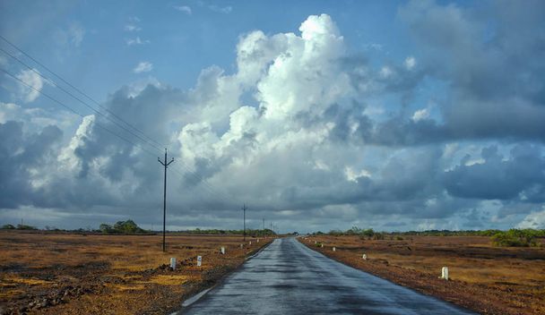 Βρεγμένο δρόμο με σκοτεινά σύννεφα κατά τη διάρκεια των μουσώνων - Φωτογραφία, εικόνα