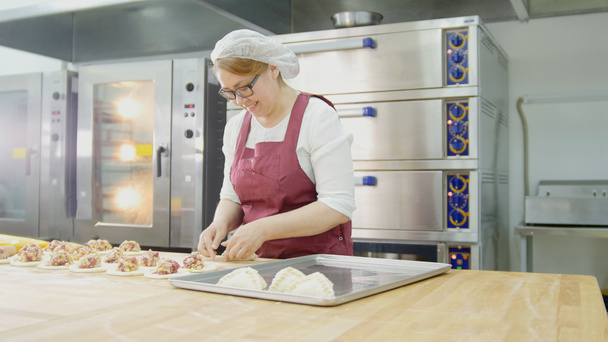 Dospělé ženy v brýlích a zástěra peče dorty v pekárně - Fotografie, Obrázek