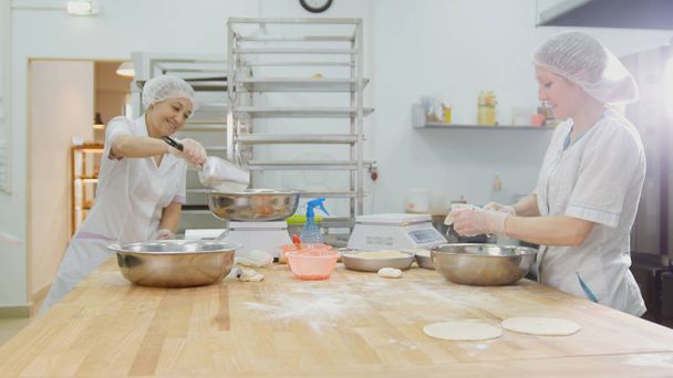 The employees female in the bakery makes fresh bread - Foto, Imagem