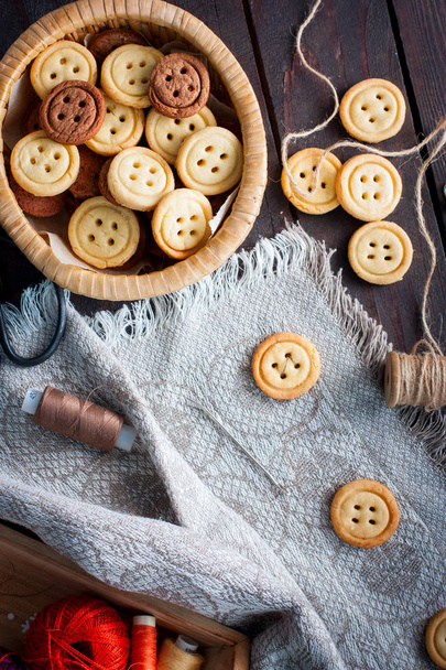 Homemade cookies in the form of buttons, imitation of the sewing process of buttons, top view, selective focus - Foto, Imagem