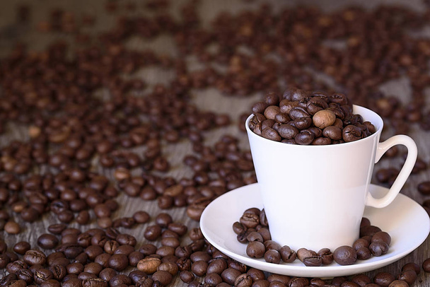Koffie concept: gebakken koffiebonen in porselein wit koffiekopje - Foto, afbeelding