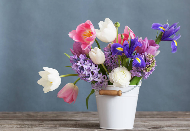 spring flowers in bucket on gray background - Foto, Imagem