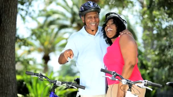 Ethnic senior happy couple keeping fit on their bicycles - Footage, Video