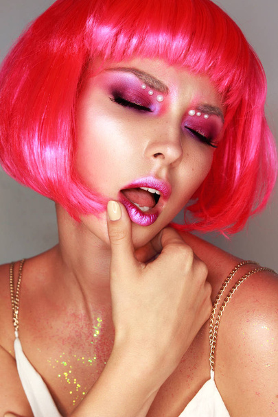 Girl in a bright pink wig with bright makeup - Фото, изображение