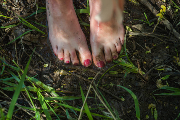 graceful girls feet in the mud - Foto, afbeelding