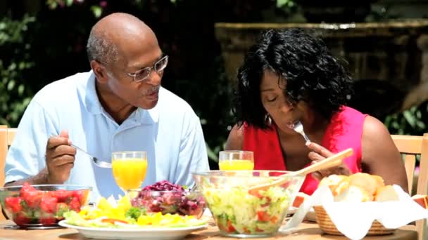 etnische senior koppel gezonde maaltijd eten in tuin - Video