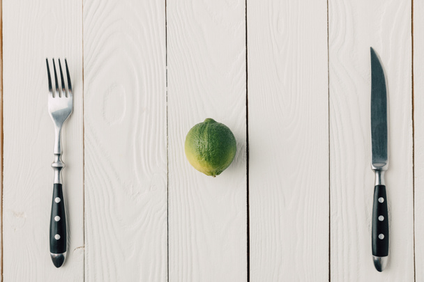 Widok z góry sztućce i zielonej limonki na białym tle drewnianych - Zdjęcie, obraz