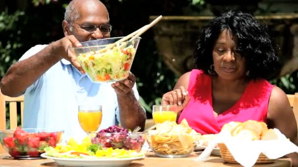 εθνοτικές ζευγάρι τρώει σαλάτα στον κήπο - Πλάνα, βίντεο