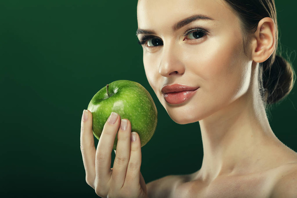 Young woman with  green apple over green background - Fotó, kép