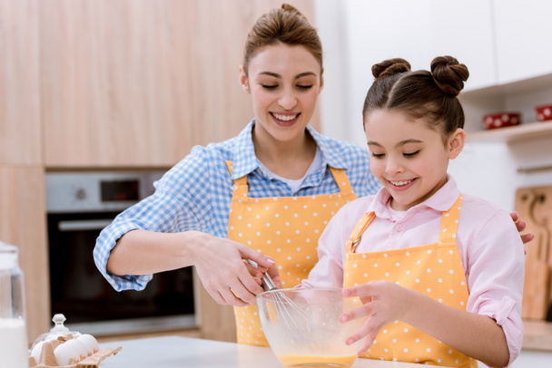 mother and daughter mixing dough for pastry together - Фото, изображение