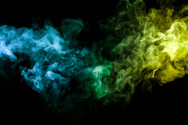 farbenfroher Rauch aus Blau, Gelb, Grün auf schwarzem, isoliertem Hintergrund. Hintergrund aus dem Rauch des Dampfes - Foto, Bild